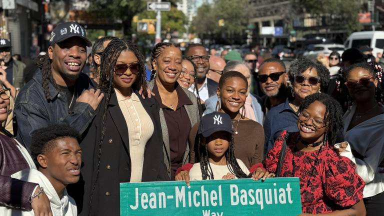 Basquiat family members holding up the new street sign on the corner of Great Jones Street and Bowery.