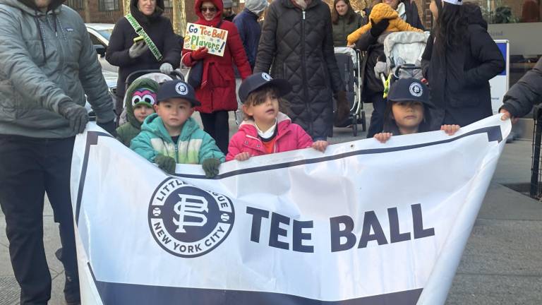Frozen tee ballers gamely hold their division sign during the opening day parade of the Peter Stuyvesant LIttle League on March 28.