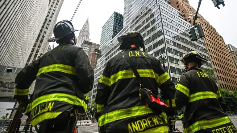 FDNY members wait outside the building at 235 E. 42nd St. where construction workers spotted buckling steel beams and sagging floors that triggered a mass evacuation of that building and surrounding buildings.